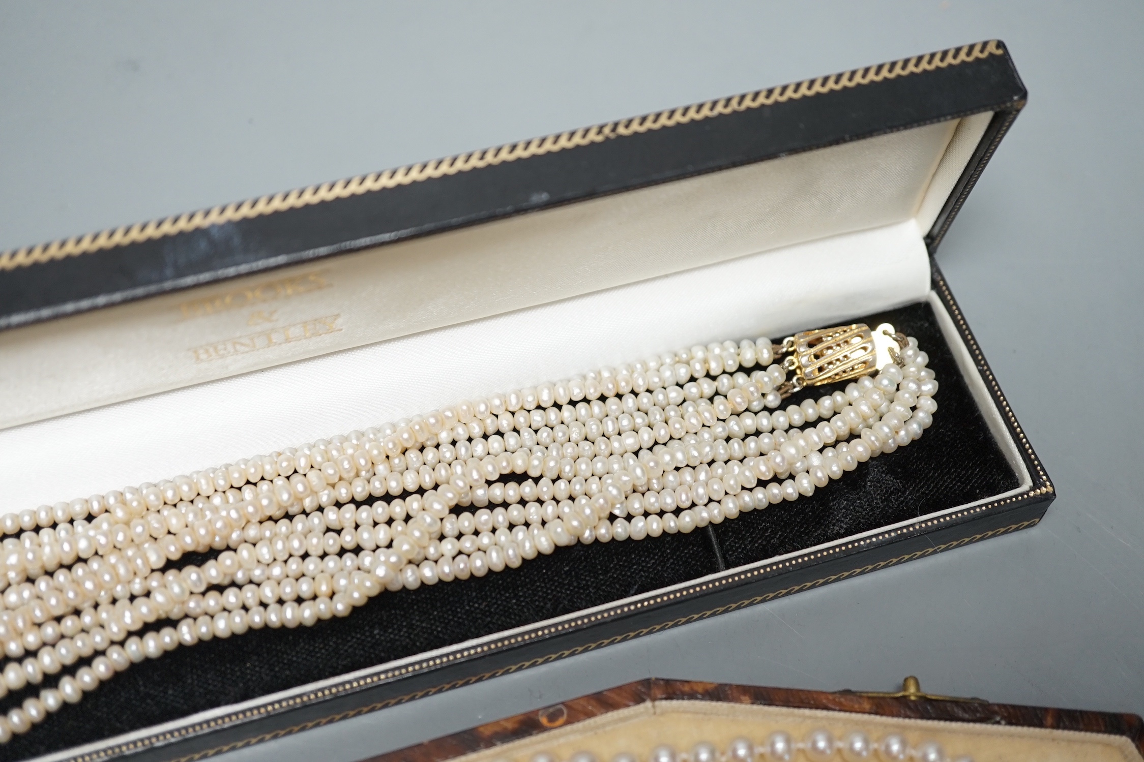 A single strand cultured pearl necklace, with sterling clasp, 44.5cm and a quadruple strand baroque seed pearl necklace, with gilt metal clasp, 42cm.